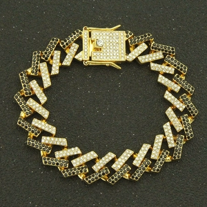 Macro detail of 15mm hip hop cuban link bracelet with gold finish and iced out crystals