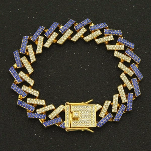 Macro detail of gold Cuban link bracelet featuring paved blue and white rhinestones