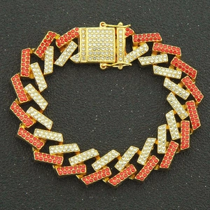 Macro view of golden Cuban link bracelet with red and white rhinestones and a square clasp
