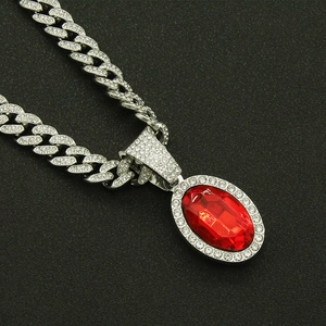 Close-up of hip-hop silver cuban chain with iced out red oval gemstone pendant