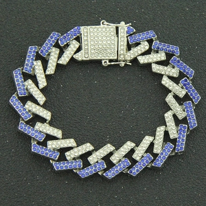 Macro detail of silver Cuban link bracelet with blue and white pavé rhinestones