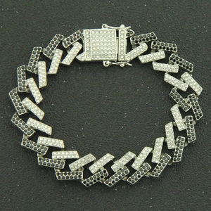 Detailed view of silver Cuban chain bracelet with black and white rhinestones and box clasp