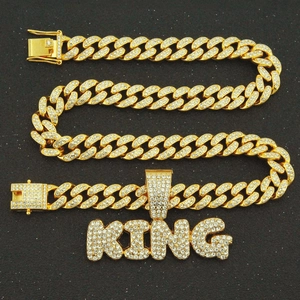 Détail macro du pendentif KING plaqué or avec zircons micro-pavés et chaîne cubaine