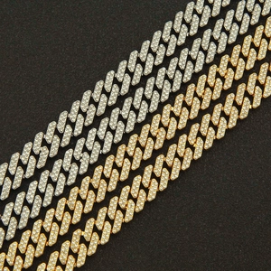 Macro shot of silver and gold iced-out Cuban link chains with shimmering crystals