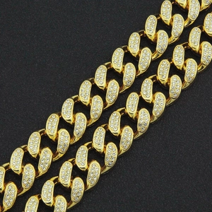 Dettaglio macro del bracciale a catena cubana dorata con micro pavé di zirconi