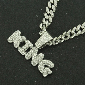 Vue macro du pendentif lettre KING glacé avec strass et chaîne à maillons cubains brillante