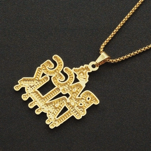 Détail du pendentif hip-hop doré avec lettre artistique et texture métallique pointillée