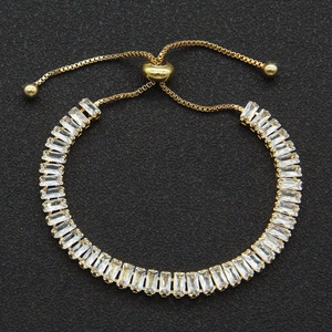 Adjustable gold bracelet featuring rectangular zircon stones on a black textured background