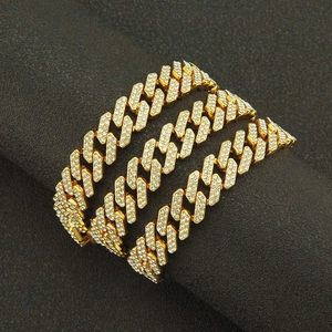 Macro detail of the iced out gold Cuban link necklace with sparkling crystals