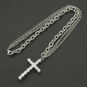 Détail d'une chaîne hip-hop argentée à double couche avec pendentif croix en zircon
