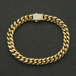Gros plan d'un bracelet gourmette doré avec fermoir rectangulaire serti de zircons blancs