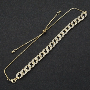 Adjustable gold Cuban link bracelet with sparkling cubic zirconia crystals on black background