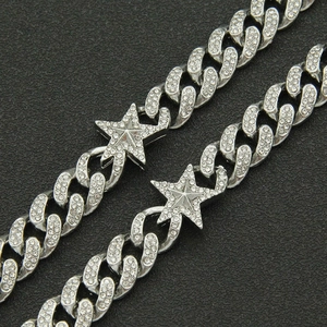 Close-up of iced out silver Cuban link chain with 3D star charms and micro-pave crystals