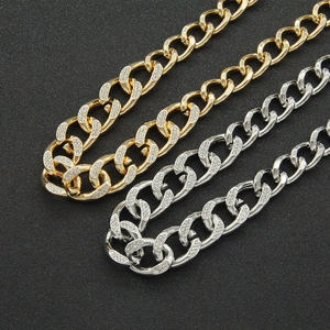 Primer plano detallado de cadenas cubanas de oro y plata con cristales de estrás brillantes