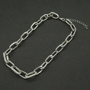 Detailed shot of silver Cuban link necklace featuring three crystal encrusted rectangular links
