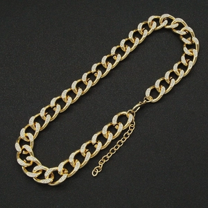 Detailed view of gold Cuban link chain necklace with sparkling pave crystal rhinestones