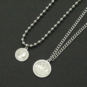 Layered silver coin necklace set featuring ball chain and curb chain on black background