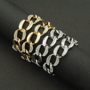 Chunky gold and silver Cuban link necklaces with white diamonds on a black stand