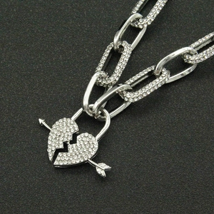 Punk style silver Cuban chain necklace with iced-out broken heart and arrow pendant