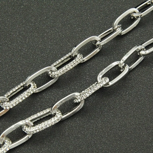 Macro shot of silver paperclip chain featuring alternating pavé crystal link detailing