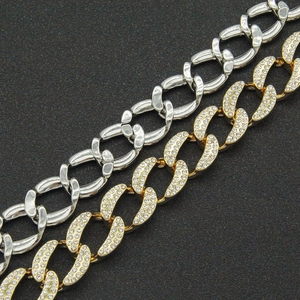 Dettaglio della catena cubana dorata con strass e catena d'argento per donna