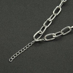 Detail of silver Cuban link necklace featuring a lobster clasp and adjustable extension chain