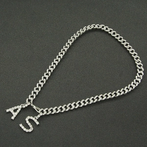 Detail of silver Cuban chain with sparkling rhinestone A and S initial pendants