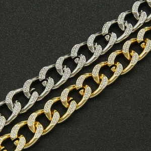 Macro detail of iced-out Cuban link chains in gold and silver with zircon pavé setting
