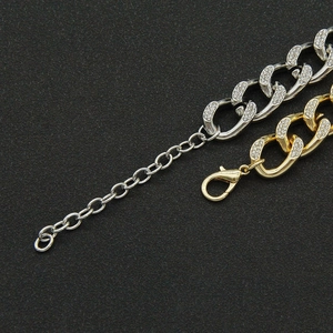 Close-up of gold and silver cuban link chains with iced out rhinestones and lobster clasp