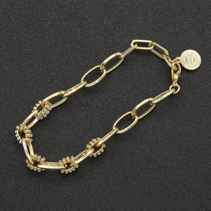 Gold chain bracelet with zircon-encrusted links and a vintage 1945 coin pendant charm
