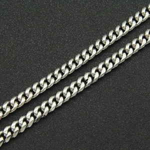 Close-up of polished silver stainless steel curb chain links with industrial metallic luster