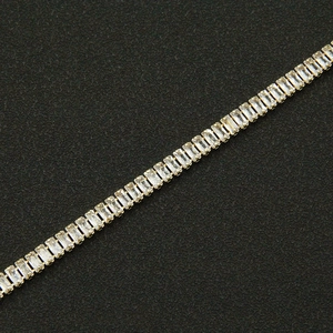 Detailed close-up of a gold-plated necklace with baguette-cut cubic zirconia settings