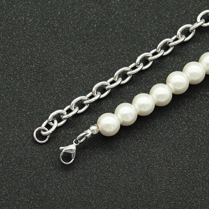 Detailed view of pearl and Cuban chain splice necklace featuring a secure lobster clasp