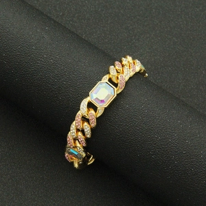 Détail d'un bracelet gourmette hip hop avec diamants roses et une pierre précieuse colorée