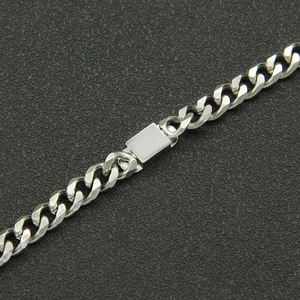 Macro shot of silver Cuban chain bracelet with a smooth rectangular engravable metal plate