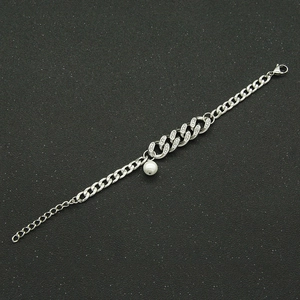 Silver Cuban chain bracelet with pavé rhinestones and a white pearl charm on dark background