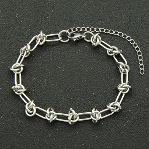 Silver stainless steel paperclip chain bracelet with adjustable lobster clasp on black background