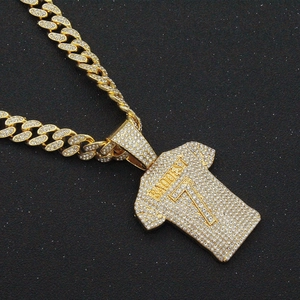 Close-up of iced out golden jersey pendant with Baddest 7 engraving and Cuban chain