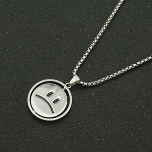 Detail of silver rotatable sad face pendant on a bead chain with hip hop style
