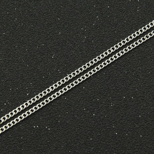Macro shot of silver Cuban link chain in titanium steel with polished interlocking links
