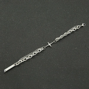 Détail d'un bracelet gourmette argenté à double épaisseur avec pendentif étoile