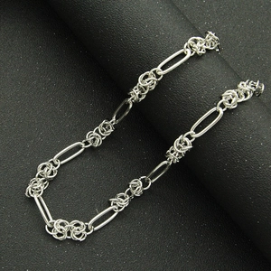 Handmade minimalist silver link chain necklace on textured black display stand