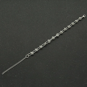 Macro detail of industrial silver stainless steel twisted link bracelet with lobster clasp
