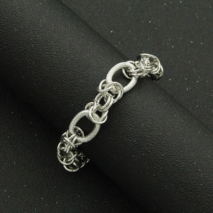 Industrial style silver chain necklace with textured interlocking links on display stand