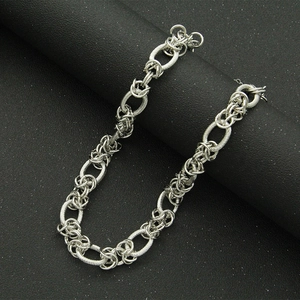 Detail of silver interlocking chain links with frosted texture on dark background