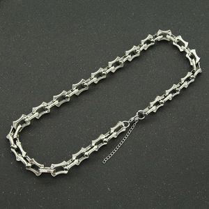 Detail of silver dragon bone chain necklace with geometric links and lobster clasp