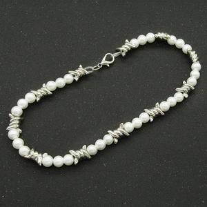 Détail du collier de perles et maillons métalliques argentés avec fermoir mousqueton