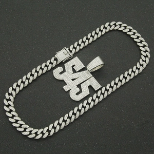 Detailed view of silver cuban chain with hip-hop letter pendant and pavé rhinestones