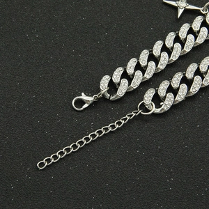 Bracelet gourmette argenté serti de strass avec pendentif étoile sur fond noir