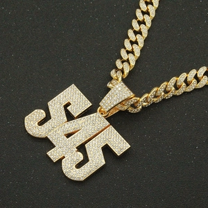 Detailed view of luxury gold Cuban chain necklace with iced-out YSL letter pendant